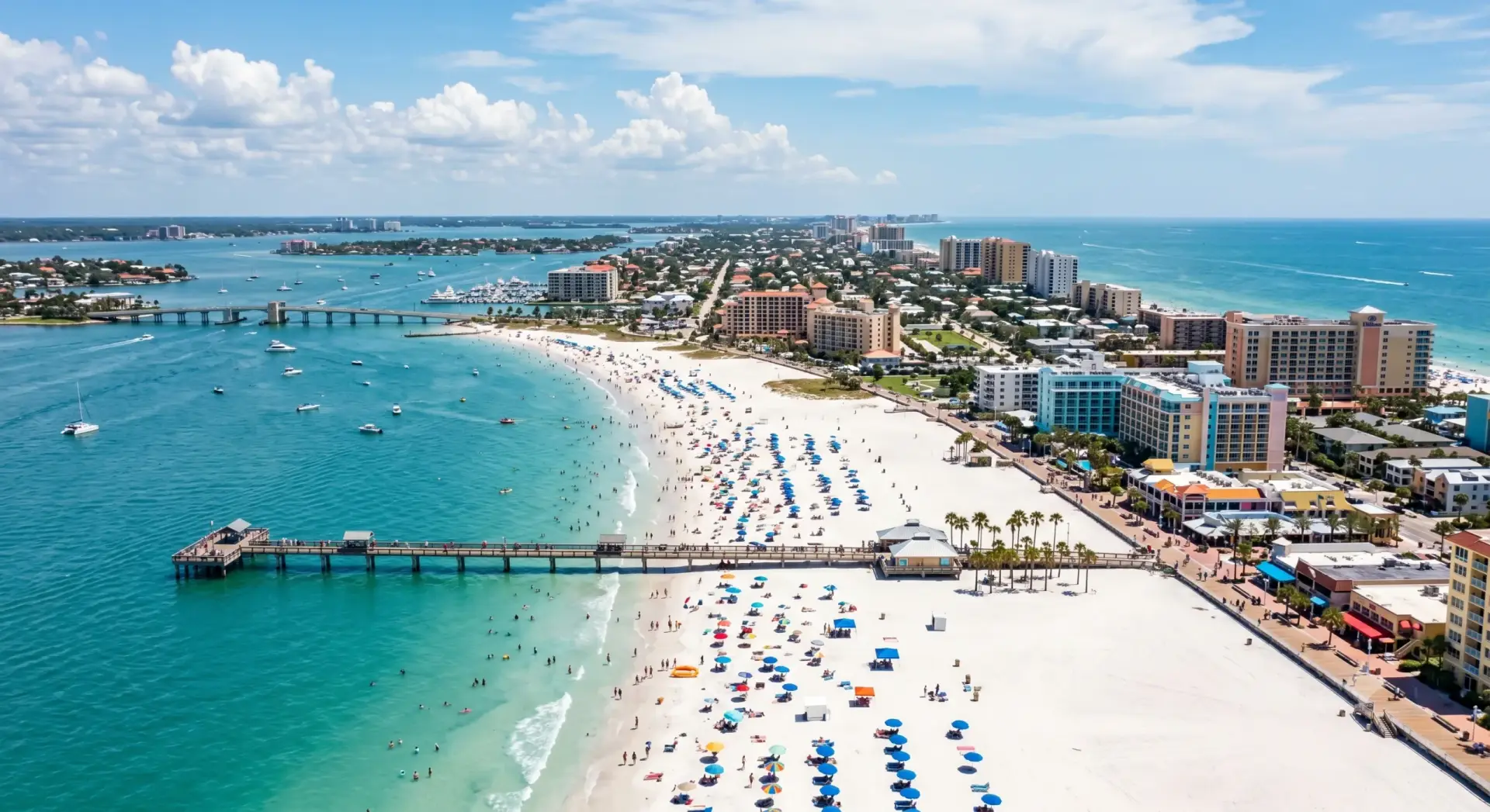 Sunny coastline view near premium Tile Installation Clearwater Beach Island with a long wooden pier and resort hotels.