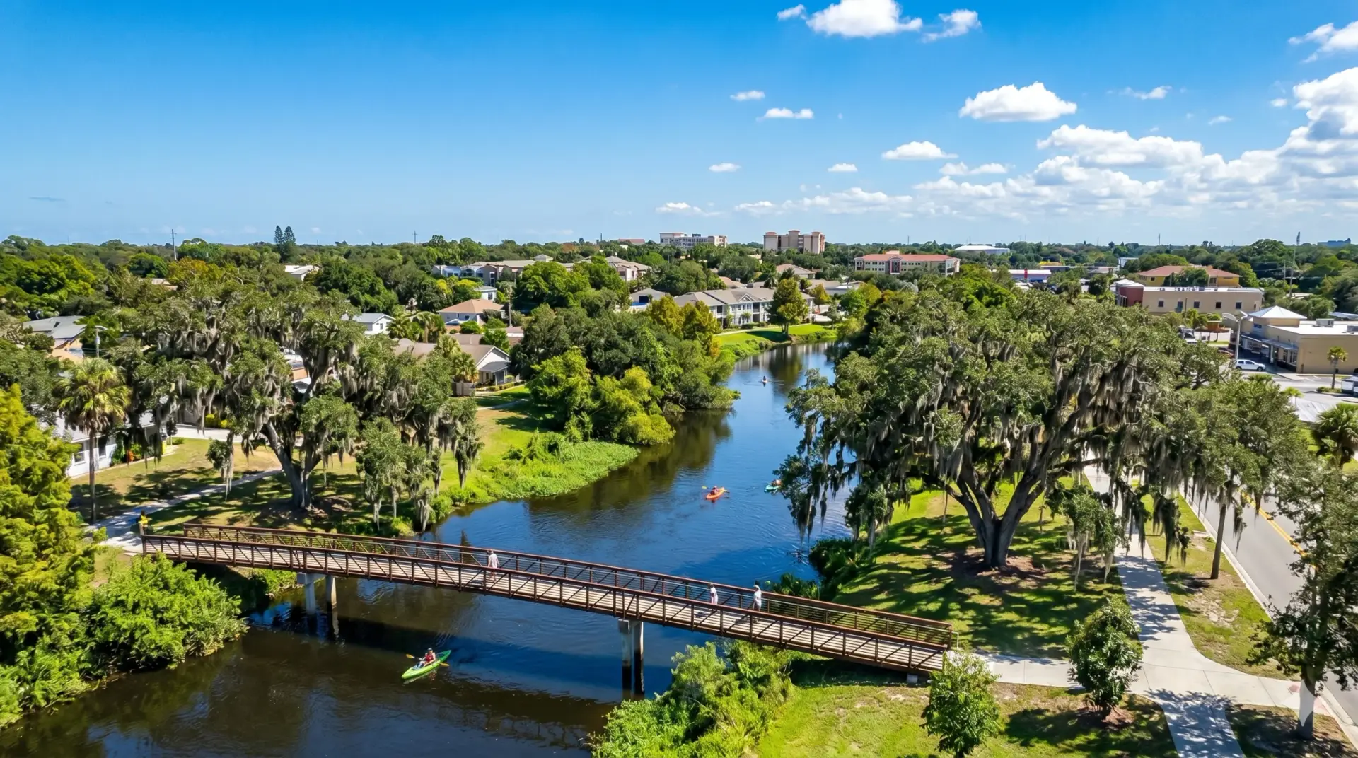 Kayakers enjoy the river by a walking bridge near our Tile Installation Temple Terrace facility.